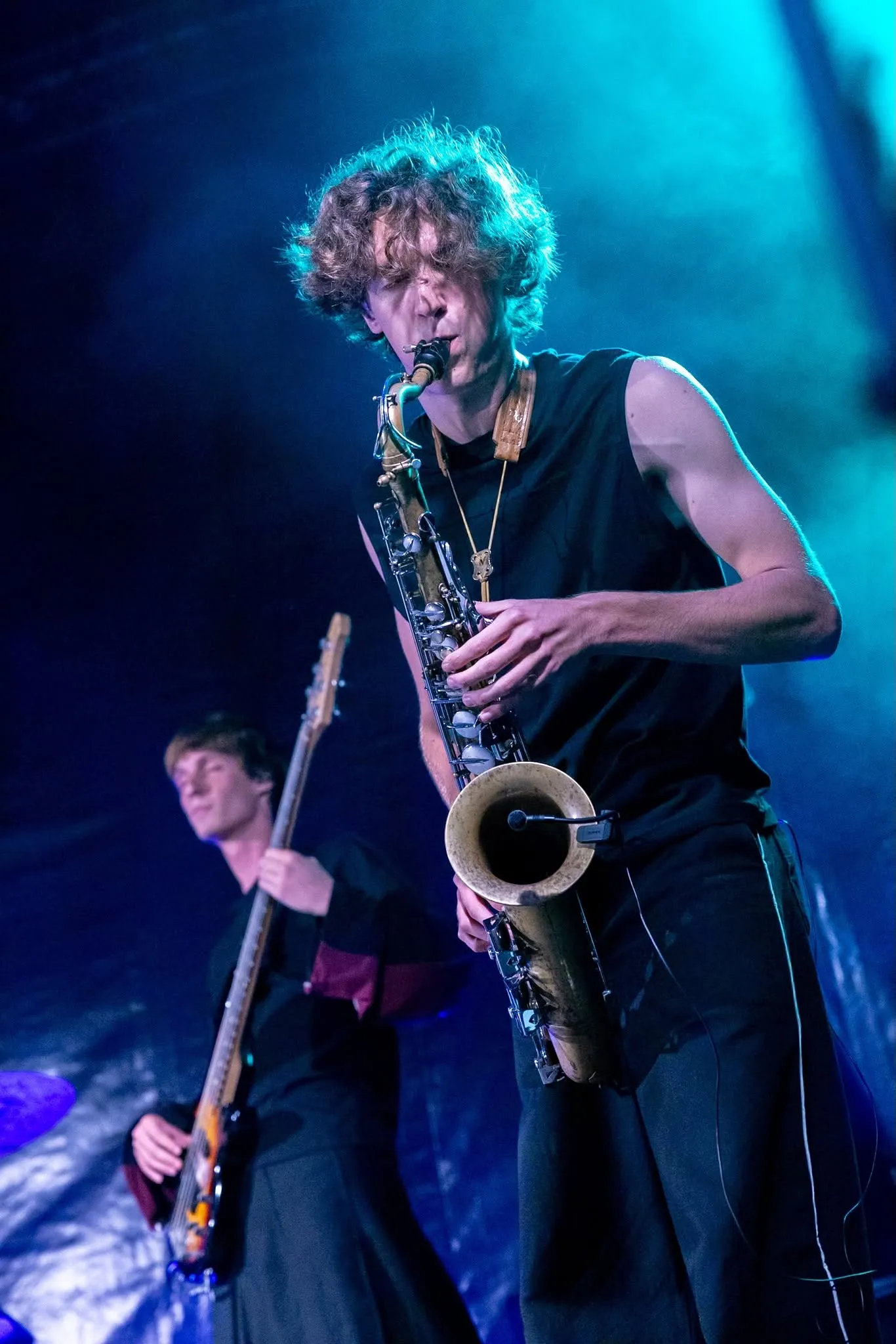 Een saxofonist speelt in blauw licht, met een bassist achter hem.